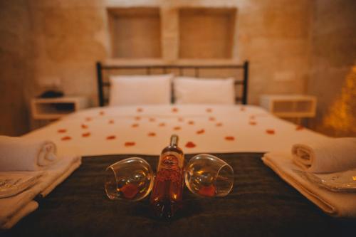 a bed with a pair of glasses on a table at DAPHNE CAVE HOTEL in Avanos