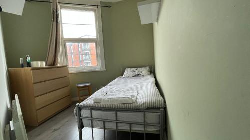 a small bedroom with a bed and a window at Single Room near Paddington in London
