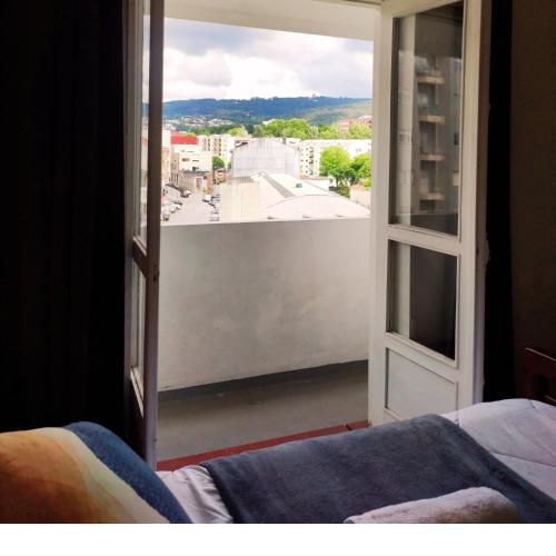a bedroom with a view of a city from a window at Liberdade Home Royal direito in Braga