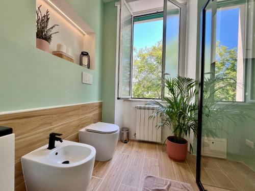 a bathroom with a sink and a toilet and a window at DMC Residence - Alloggi Turistici in Anzio
