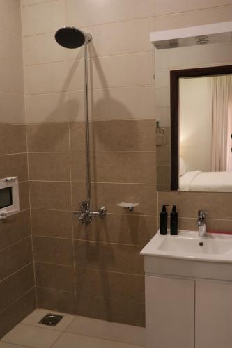 a bathroom with a shower with a sink and a mirror at Zen Haven by StayMehman in Rawalpindi
