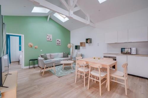 une cuisine et un salon avec une table et des chaises dans l'établissement Le Rayon Vert - Appt dans le centre de Bordeaux, à Bordeaux