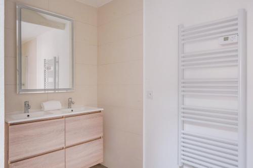 une salle de bain avec un lavabo et un miroir dans l'établissement Le Rayon Vert - Appt dans le centre de Bordeaux, à Bordeaux