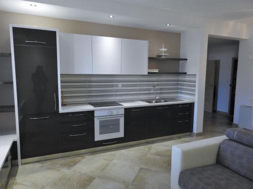 a large kitchen with a sink and a stove at Villa Barbara Apartments in Sumartin