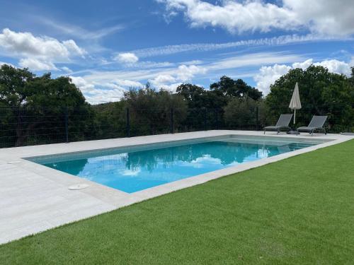 una piscina en un patio con 2 sillas en Casa Rural Camino de la Data, en Valencia de Alcántara