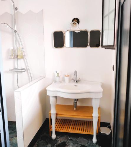 une salle de bain avec un lavabo blanc et une douche dans l'établissement Villa Andernos les Bains, à Andernos-les-Bains