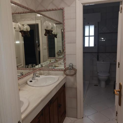 a bathroom with a sink and a toilet and a mirror at Playa de Comillas in Comillas