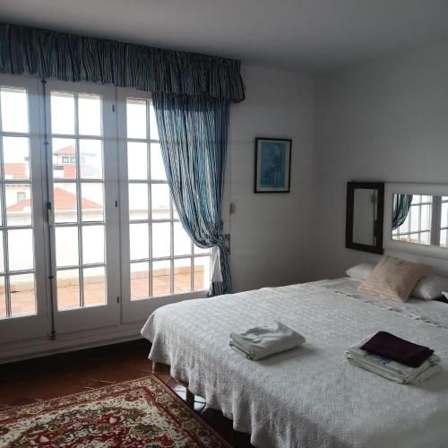 a bedroom with a bed and a large window at Playa de Comillas in Comillas