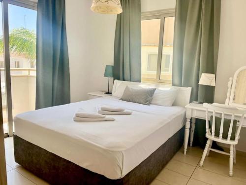 a bedroom with a large bed with towels on it at Eliza Suite at Pernera Beach in Protaras