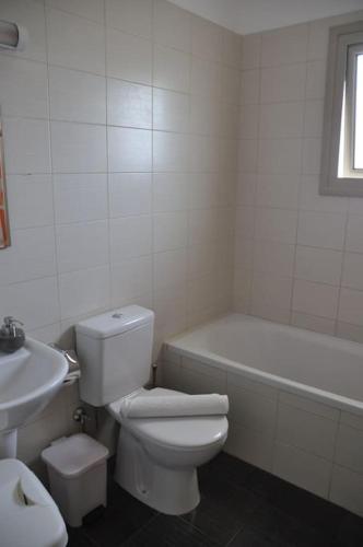 a bathroom with a toilet and a tub and a sink at Eliza Suite at Pernera Beach in Protaras