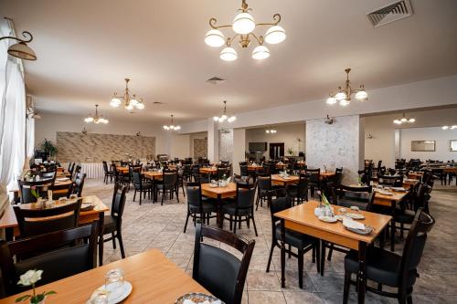 Nowe Łazienki Mineralne في كرينيتسا زدروي: غرفة طعام مع طاولات وكراسي خشبية
