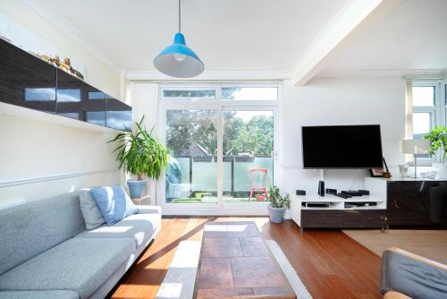 ein Wohnzimmer mit einem Sofa und einem Flachbild-TV in der Unterkunft A Charming 1BR apartment in Bromley in Bromley