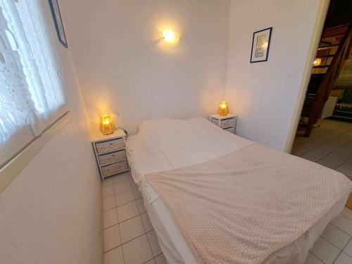 Cette petite chambre comprend un lit avec deux lumières. dans l'établissement Appartement 1 chambre et mezzanine, 4-6 couchages, parking privé - FR-1-326-505, à Marseillan