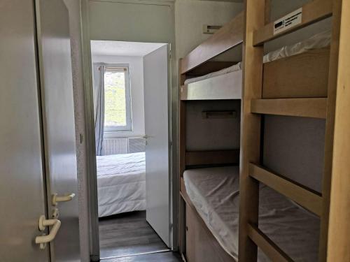 Cette petite chambre comprend des lits superposés et une porte. dans l'établissement Appartement 6 pers - 1 ch - Balcon sud - Pied des pistes - La Mongie - FR-1-404-24, à La Mongie