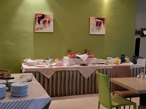 un comedor con 2 mesas con platos en ASTIR COSY LIVING HOTEL en Áyios Konstandínos