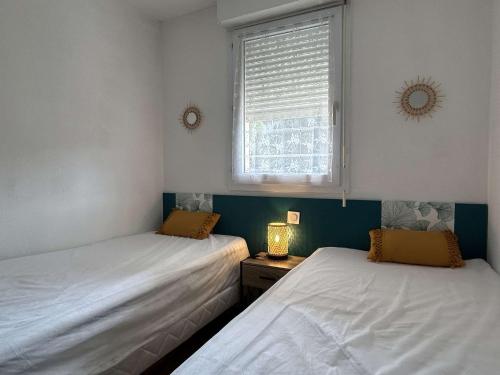 deux lits dans une chambre avec une fenêtre dans l'établissement Appartement 2 pièces climatisé avec terrasse et parking à Banyuls-sur-Mer - FR-1-225C-500, à Banyuls-sur-Mer