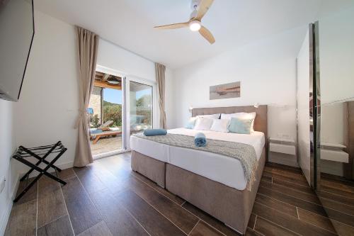 a bedroom with a bed with a ceiling fan at Papa's Court V Pasman Villa with pool in Pašman