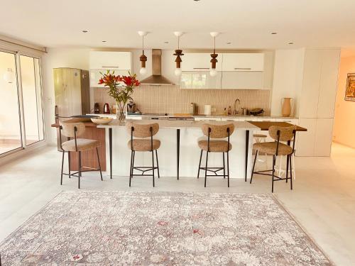 une cuisine avec un grand îlot et des tabourets de bar dans l'établissement Mon Eden au soleil de Saint-Tropez, à Saint-Tropez