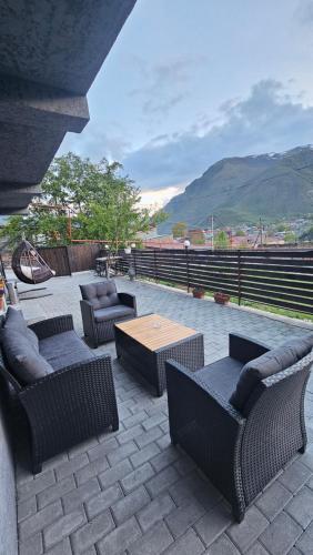 a patio with couches and a table and a view of a mountain at Best view Kazbegi in Kazbegi
