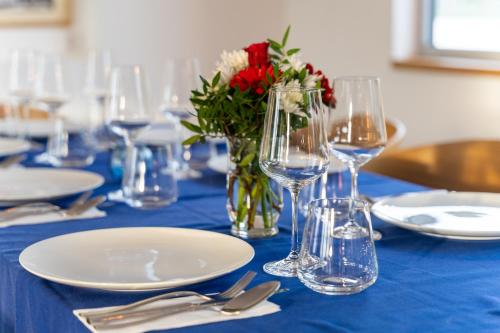 a blue table with glasses and a vase of flowers at Botel Racek in Prague