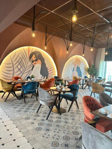 un restaurant avec des tables et des chaises et une fresque murale. dans l'établissement DAMAC Maison Aykon City Dubai, à Dubaï