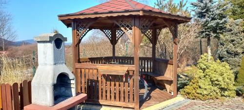 a wooden gazebo with a tower next to a pool at Słoneczne zbocze in Wysowa-Zdrój