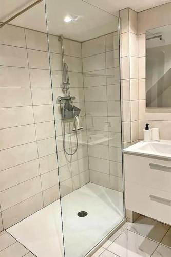 une douche avec une porte vitrée dans une salle de bain dans l'établissement La Funky Coloc', à Saint-Étienne