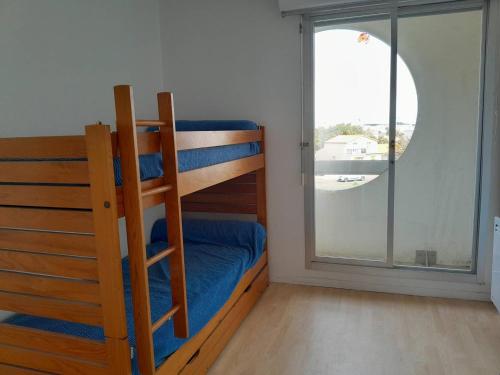 Ce lit superposé se trouve dans un dortoir doté d'une fenêtre. dans l'établissement Saint Gilles - T3 Face Mer avec Balcon, Parking Privé, Accès Direct Plage - FR-1-324-543, à Saint-Gilles-Croix-de-Vie