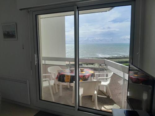 un balcon avec une table et des chaises et l'océan dans l'établissement Saint Gilles - T3 Face Mer avec Balcon, Parking Privé, Accès Direct Plage - FR-1-324-543, à Saint-Gilles-Croix-de-Vie