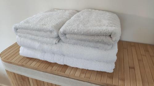 a stack of white towels sitting on a wooden shelf at La parenthèse sous les toits in Fontainebleau