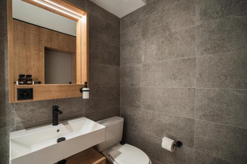 a bathroom with a sink and a toilet and a mirror at Hotel Brocco & Posta in San Bernardino