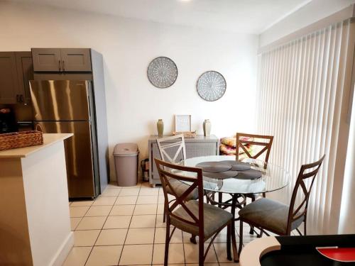 a kitchen with a table and chairs and a refrigerator at Walk to Hard Rock ~ Amazing 5 Star Home Away From Home! in Miami Gardens