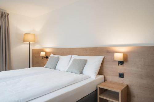 a bedroom with a large white bed and a table at Hotel Brocco & Posta in San Bernardino