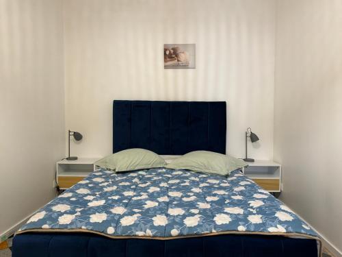 a bedroom with a large bed with a blue headboard at L'APPARTEMENT BOULONNAIS in Boulogne-sur-Mer