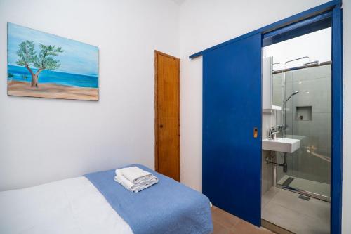 a bedroom with a blue door leading to a bathroom at Babis & Popi Rooms and Studios in Frangokastello