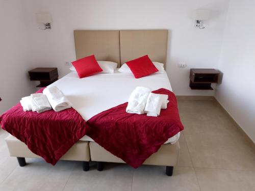 菲烏米奇諾的住宿－Vinci Residence，一间卧室配有两张带红白色枕头的床