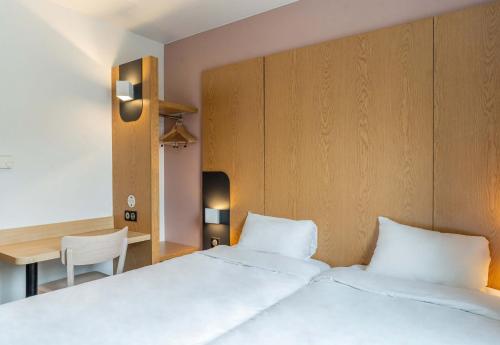 a bedroom with two beds and a table and a desk at B&B HOTEL Aix-en-Provence Le Tholonet in Aix-en-Provence