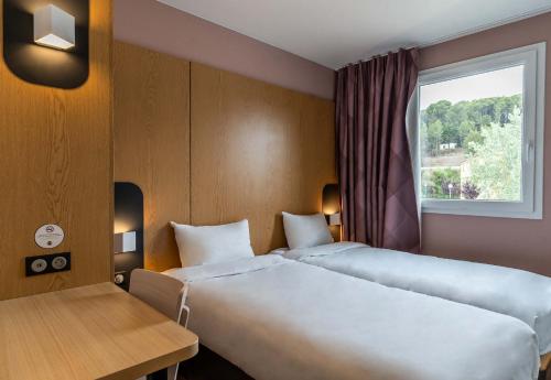 普羅旺斯艾克斯的住宿－B&B HOTEL Aix-en-Provence Le Tholonet，酒店客房设有两张床和窗户。