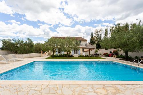 une piscine devant une maison dans l'établissement Côté Oliviers 6P - Appt avec piscine partagée, à Beaucaire