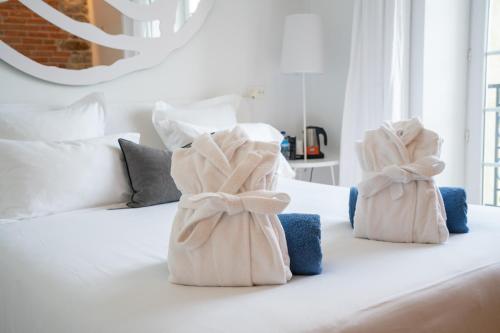 two towels are sitting on top of a bed at Les Garennes - Hôtel Spa Bénodet in Bénodet