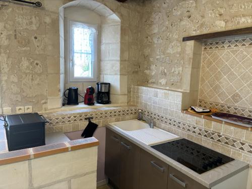 a kitchen with a stove and a sink and a window at Domaine de la RIMBERTIÈRE in Thuré