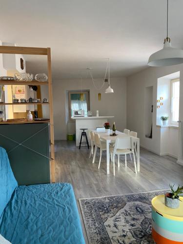 a living room and kitchen with a table and chairs at Casi di Lisi, la luce sulla piazza e sulle montagne in Lisignago