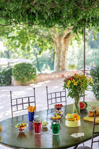 - une table avec des bols de fruits et de fleurs dans l'établissement La Grande Verrière - MH, à Goult