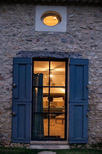 une fenêtre avec des portes bleues dans un bâtiment en pierre dans l'établissement La Grande Verrière - MH, à Goult