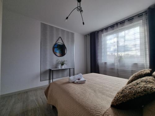 a bedroom with a bed with two towels on it at Q Apart Meta -1, 2 lub 3-pokojowe, klimatyzowane apartamenty przy Manufakturze z garażem lub parkingiem Gratis, FV in Łódź