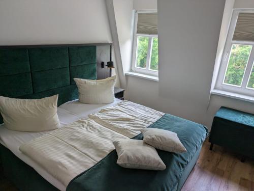 a bedroom with a large bed with pillows on it at Seehotel Ecktannen in Waren