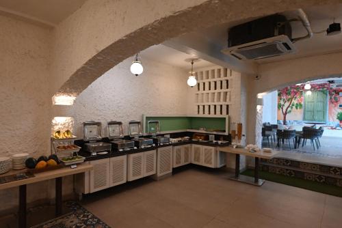 a large kitchen with an archway in a room at Little Chef Hotel in Kānpur