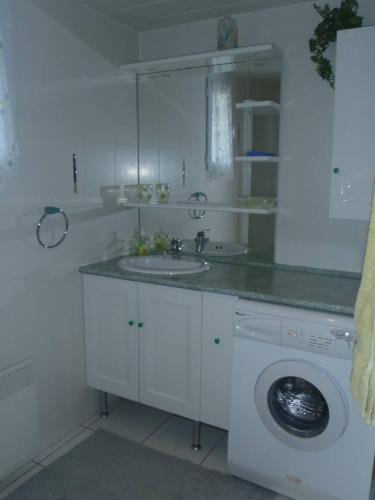 La salle de bains blanche est pourvue d'un lavabo et d'un lave-linge. dans l'établissement VILLA 3 PIECES MEZ 55m2 + TERRASSE 14m2 REF 4017, à Le Castellas