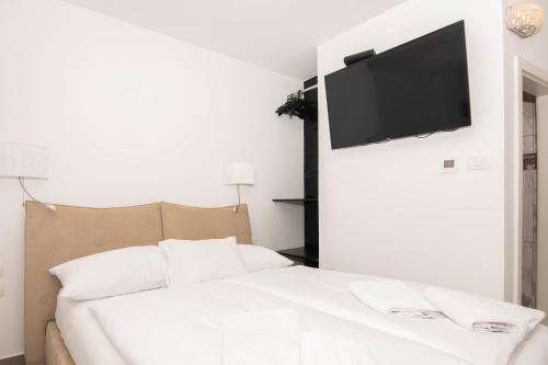 a bedroom with a bed with a television on the wall at Bed and Brekfast Donatella in Piran