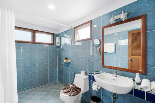 ein blau gefliestes Badezimmer mit Waschbecken und Toilette in der Unterkunft Anahata Resort in Lipa Noi